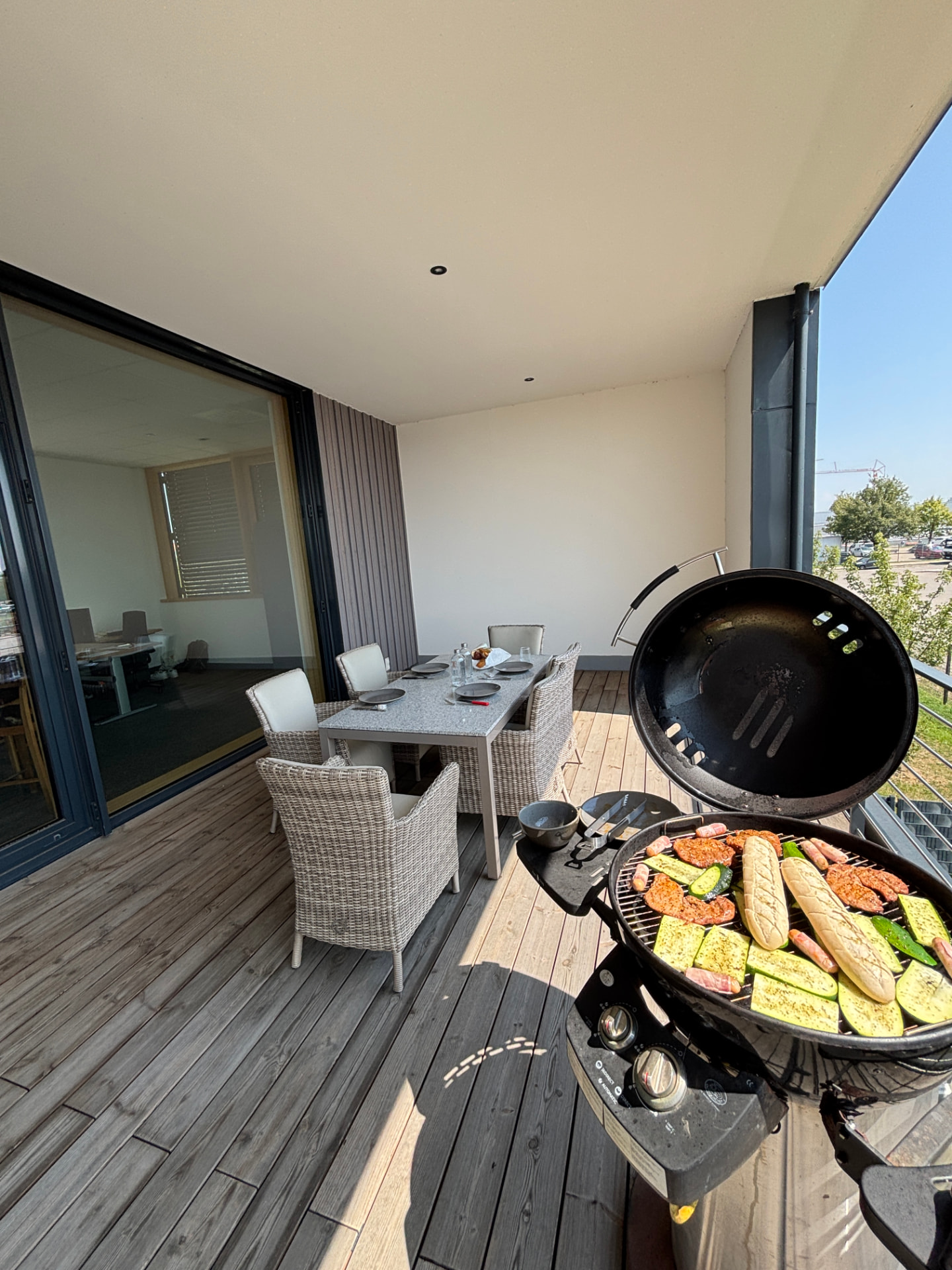 Grill mit Gemüse und Würstchen auf der Büroterrasse